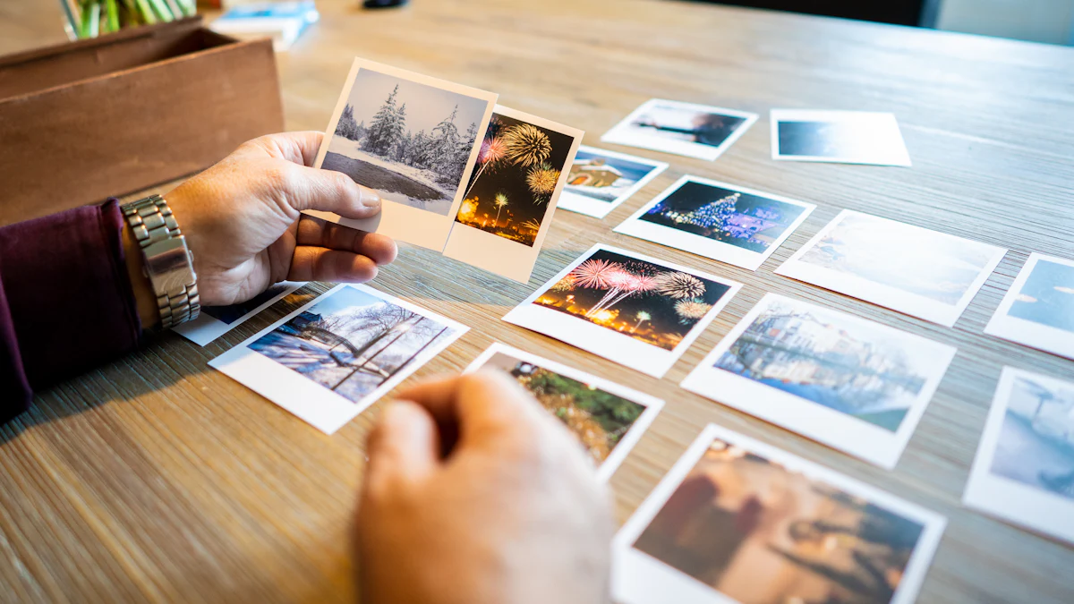 Hands sorting through printed photos laid out in rows on a wooden table